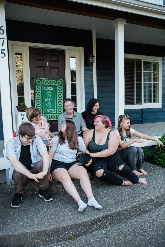 Family sitting on their porch during documentary family photo session in Lacey, WA