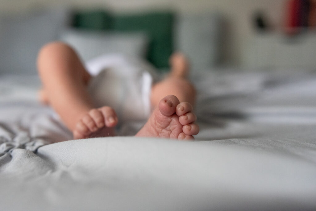 Close up image of baby's toes curled with a blurred background.