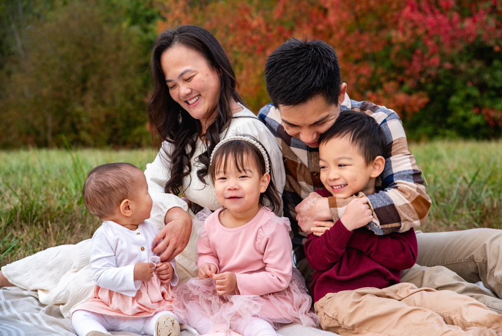 Choosing images that are genuine and feel like your family are the best ones to pick when putting together your holiday cards. These parents are interacting with their kids with tickles and giggles.