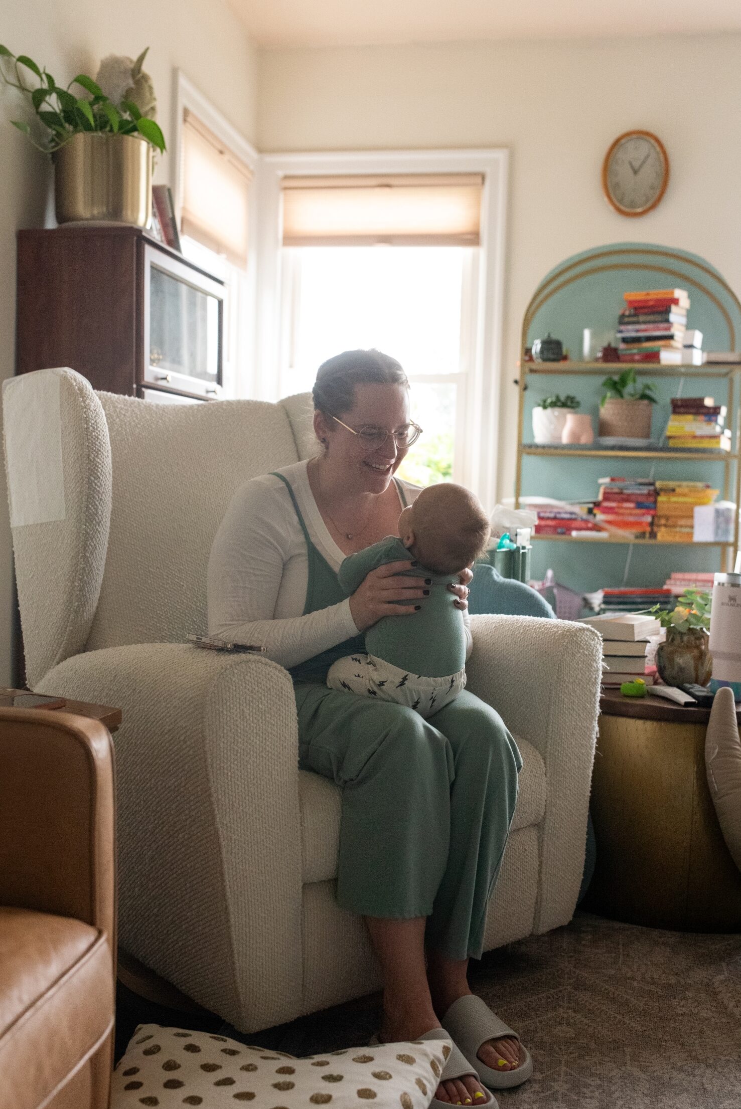 Mom nursing newborn in rocking chair at home, lifestyle newborn photographer Tacoma.