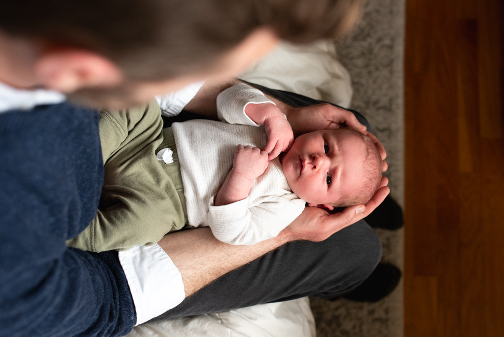 Dad holding newborn baby at home, lifestyle newborn photography Sumner.