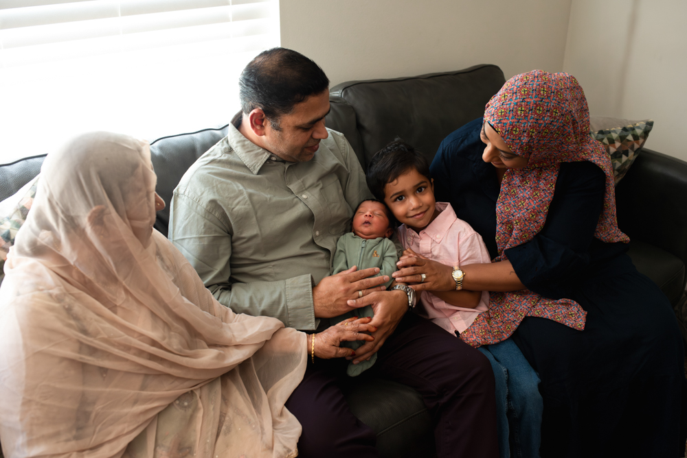3 generations together on the couch during a newborn photoshoot at home
